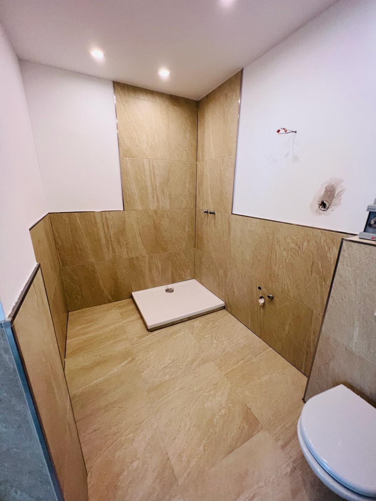 Bad in Naturstein-Optik mit bodengleicher Dusche